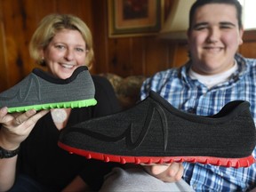 Broc Brown, right, shows off his new shoes with Feetz CEO Lucy Beard at his grandmother's home in Michigan Center, Mich. on March 1. Brown, who has Sotos Syndrome and is 7 feet, 8 inches tall, was given a new pair of about size 28 shoes from Feetz.