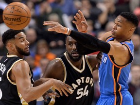 Oklahoma City Thunder guard Russell Westbrook moves the ball past the Raptors' Cory Joseph and Patrick Patterson during first half action, in Toronto on Thursday night.