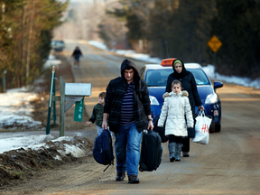 A family crosses the Canada-U.S. border into Quebec in order to seek asylum in 2017.