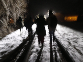 Migrants from Somalia cross into Canada illegally from the U.S. by walking down a train track into Emerson, Manitoba, on Feb. 26.