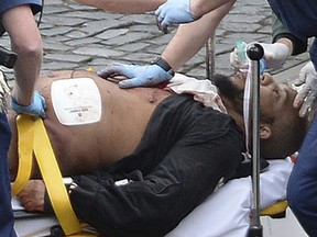 In this March 22, 2017 file photo, the attacker Khalid Masood is treated by emergency services outside the Houses of Parliament in London.