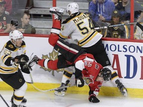 Defenceman Adam McQuaid of the Boston Bruins collides with Mike Hoffman of the Ottawa Senators during NHL action Monday in Ottawa. Hoffman had the game-winning goal as the Sens posted a 4-2 victory over their Atlantic Division rival.