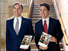 Finance Minister Bill Morneau and Prime Minister Justin Trudeau hold copies of the federal budget in March.