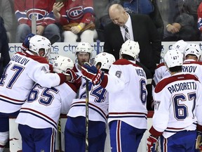 Montreal Canadiens head coach Claude Julien, centre, stands with his players against the New Jersey Devils on Feb. 27.