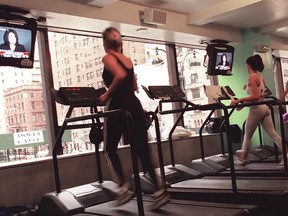 While running on the treadmills, women watch television at a New York gym.