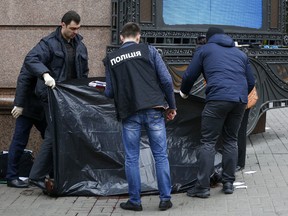 Forensic experts and police officers examine the scene following the killing of Denis Voronenkov in Kyiv, Ukraine, Thursday, March 23, 2017.