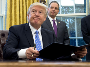 President Donald Trump signs an executive order withdrawing the U.S. from the Trans-Pacific Partnership trade deal, Jan. 23, 2017.