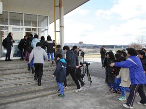 Local residents move towards a school gymnasium during an evacuation drill at Oga city, Akita prefecture on March 17, 2017.