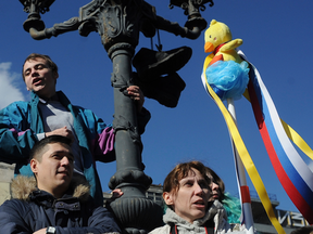 A woman holds up a yellow duck toy during protests in downtown Moscow, Russia, on March 26, 2017.