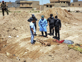 In this April 19, 2016 file photo, an Iraqi security forces forensic team works at the site of a mass grave believed to contain the bodies of Iraqi civilians, security forces and members of their families