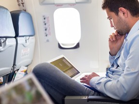 A file photo of an man with a laptop on a plane