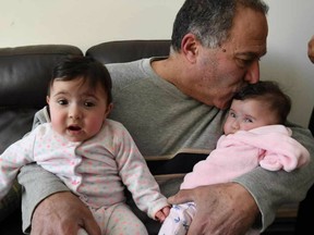 Edward Haddad holds his two daughters at his Tecumseh, Ontario home on March 15, 2017.