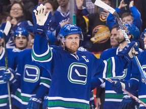 Vancouver Canucks captain Henrik Sedin waves as he receives a standing ovation after scoring a goal against the Florida Panthers to record his 1,000th career point on Friday, Jan. 20, 2017.