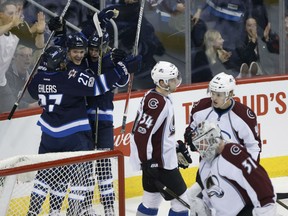 Nikolaj Ehlers, Mark Scheifele, centre, and Patrik Laine of the Jets celebrate Scheifele's goal against Colorado Avalanche netminder Calvin Pickard during first period action in Winnipeg on Saturday night.