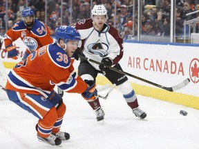 Drake Caggiula of the Oilers vies for the puck against Colorado Avalanche's Carl Soderberg during second period action at Rogers Arena in Edmonton on Saturday night.