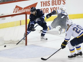 Bryan Little of the Jets scores on an empty net after beating St. Louis Blues' Alex Pietrangelo in a rush for the puck as Alexander Steen follows up too late during third period action in Winnipeg on Friday night.