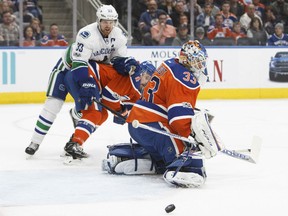 Oilers goalie Cam Talbot makes a stop as Vancouver Canucks' Henrik Sedin vies for position in front of the net during first period action in Edmonton on Saturday night.
