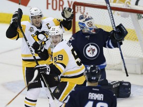 Pittsburgh Penguins' Jake Guentzel and Sidney Crosby celebrate Guentzel's goal against Jets goalie Michael Hutchinson during third period action in Winnipeg on Wednesday night.