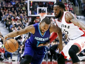 Kemba Walker, left, of the Charlotte Hornets tries to work the ball around Toronto Raptors' defender DeMarre Carroll during NBA action Wednesday night at ACC. Walker had 19 points in the Hornets' 110-106 victory, snapping the Raptors' winning streak at six games.