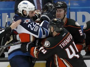 Chris Thorburn, left, of the Winnipeg Jets, looks to mix it up against Chris Wagner, right, and Nate Thompson of the Anaheim Ducks during NHL action Friday night in Anaheim. The Ducks were 3-1 winners over the Jets who have been eliminated from playoff contention.
