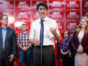 Prime Minister Justin Trudeau, centre, speaks to the media during a byelection campaign event in Calgary, Alta., Wednesday, March 1, 2017.