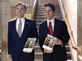 Finance Minister Bill Morneau and Prime Minister Justin Trudeau hold copies of the federal budget in the House of Commons in Ottawa, Wednesday, March 22, 2017.