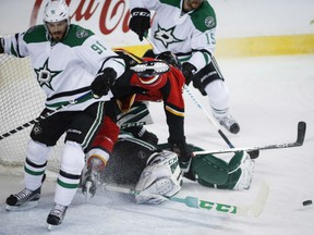 Calgary Flames' captain Mark Giordano runs over Dallas Stars' goaltender Kari Lehtonen after being upended by Tyler Seguin, left, during NHL action Friday night in Calgary. Giordano had a goal and two assists as the Flames posted a 3-1 victory.