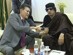 Kirsan Ilyumzhinov, left, meets then-Libyan leader Moammar Gadhafi, right, in Tripoli.