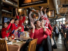 In this Feb. 21, 2014 file photo, hockey fans at a restaurant in London, Ont., cheer Team Canada's semifinal win over the U.S. at the Sochi Olympics.