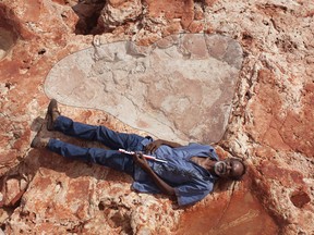 Goolarabooloo cultural leader Richard Hunter poses alongside a sauropod track in Western Australia's Dampier Peninsula.