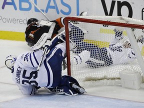 Toronto Maple Leafs goalie Curtis McElhinney, front, takes a tumble after he collided with teammate Nazem Kadri, background right, and Anaheim Ducks forward Andrew Cogliano on March 3.
