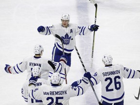 Toronto Maple Leafs' Morgan Rielly (44) celebrates his game-winning goal in overtime against the Carolina Hurricanes with teammates Zach Hyman, Curtis McElhinney and Nikita Soshnikov in Raleigh, N.C., on Saturday night. Toronto won 3-2.