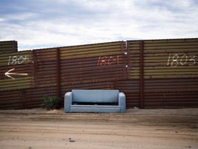 A sofa sits abandoned against the border fence on the US/Mexico border in Tecate, California on on February 14, 2017.
