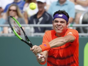 Milos Raonic returns a shot against Viktor Troicki at the Miami Open in Key Biscayne, Fla., on March 24.