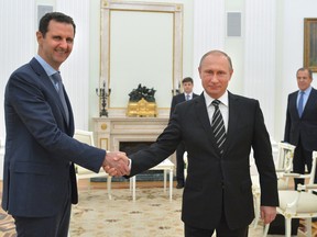 In this Oct. 20, 2015 file photo, Russian President Vladimir Putin, center, shakes hand with Syrian President Bashar Assad as Russian Foreign Minister Sergey Lavrov, right, looks on, at the Kremlin, in Moscow, Russia.