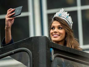 Miss Universe Iris Mittenaere takes a selfie as she salutes the crowd upon her arrival in Lille, northern France, on March 19, 2017.