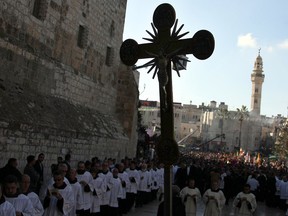 Clergy parade in manger Square outside the Church of the Nativity in the Biblical West Bank city of Bethlehem, believed to be the birthplace of Jesus Christ, in the West Bank town of Bethlehem on December 24, 2010 as the Holy Land prepares to mark Christmas.
