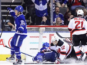 William Nylander, left, of the Toronto Maple Leafs, celebrates his goal against the New Jersey Devils in NHL action Thursday night in Toronto. Down on the ice are Leafs' Auston Matthews and New Jersey Devils' defenceman Ben Lovejoy. The goal by Nylander extended his consecutive game point streak to 10 games, a franchise record for Toronto rookies.