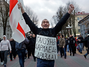 A man wears a sign reading "The main parasites are in Drozdy (presidential residence)" at a rally in Maladzyechna, Belarus, on March 10, 2017.