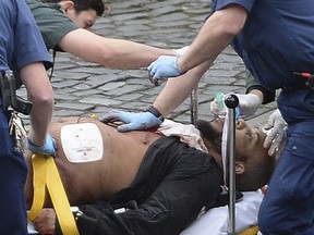 A man is treated by emergency services outside the Houses of Parliament London, Wednesday, March 22, 2017. The BBC is reporting that this is the suspect who allegedly stabbed a police officer before he was shot dead outside the U.K. Parliament in London.