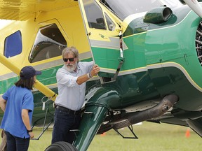 In this July 28, 2016, file photo, Harrison Ford opens the door on his plane for Jodie Gawthorp, of Westchester, Ill., who was selected to fly with Ford, at the Experimental Aircraft Associations AirVenture air show at Wittman Regional Airport in Oshkosh, Wis. Ford told an air traffic controller he was distracted and concerned about turbulence from another aircraft when he mistakenly landed his small plane on a taxiway at a Southern California airport in Feb. 2017.
