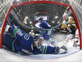 Vancouver Canucks goaltender Ryan Miller (left) sprawls to save a Phil Kessel (right) shot on March 11.