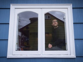 David Repa, who moved from Vancouver last year, is seen through a window while sitting for a photograph at his home in Powell River, B.C., on Thursday March 16, 2017.