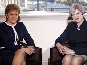 Britain's Prime Minister Theresa May, right, and  Scotland's First Minister Nicola Sturgeon sit during their meeting in Glasgow, Scotland, Monday March 27. They both have legs.