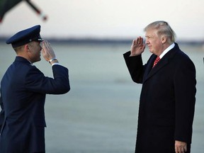President Donald Trump salutes as he stands on the tarmac after disembarking Air Force One as he arrives Sunday, March 5, 2017, at Andrews Air Force Base, Md. Trump is returning from Mar-a-Largo, Fla.