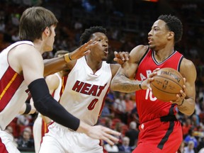 DeMar DeRozan, right, of the Toronto Raptors looks to make a play with the ball while being defensed by Miami Heat Luke Babbitt, left, and Josh Richardson, during NBA action Thursday night in Miami. DeRozan had 40 points as the Raptors posted a 101-84 victory. It was their fourth straight victory.
