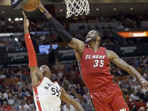 Heat forward Willie Reed blocks a shot by Toronto Raptors guard Delon Wright during the first half of their game Saturday night in Miami.