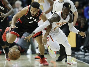 Toronto Raptors' Cory Joseph, left, reaches for a loose ball against the Hawks' Dennis Schroder in the third quarter of their game in Atlanta on Friday night. The Hawks won 105-99.