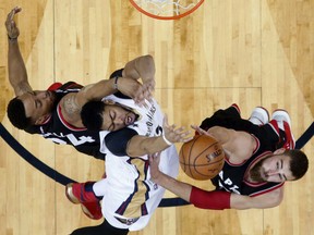 Pelicans forward Anthony Davis is fouled as he goes to the basket against the Toronto Raptors' Norman Powell, left, and Jonas Valanciunas during the first half of their game in New Orleans on Wednesday night.