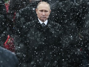 In this Thursday, Feb. 23, 2017 file photo, snow falls as Russian President Vladimir Putin attends a wreath-laying ceremony marking the Defenders of the Fatherland Day at the Tomb of the Unknown Soldier in Moscow, Russia.